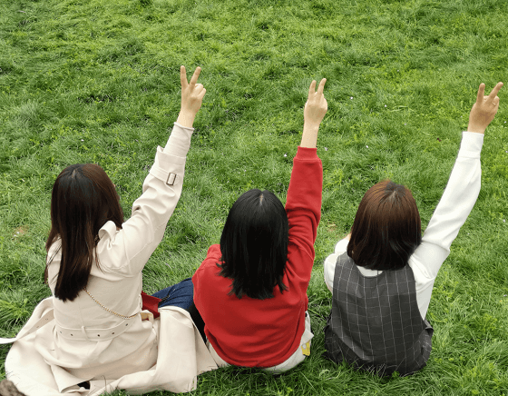 three girl sit on the lawn